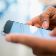 A person holding a mobile device, looking for telltale signs of an app violating their privacy